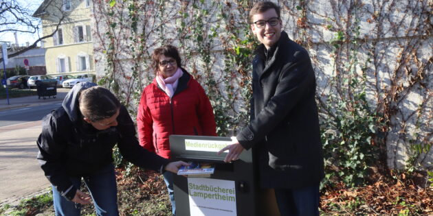 Ideengeberin Mona Rink (l.) nutzte den neuen Rückgabekasten der Stadtbücherei, um selbst Bücher einzuwerfen. Eugenia Köhler (Stadtbücherei) und der Erste Stadtrat Marius Schmidt zeigten sich von der Idee begeistert. Foto: Benjamin Kloos
