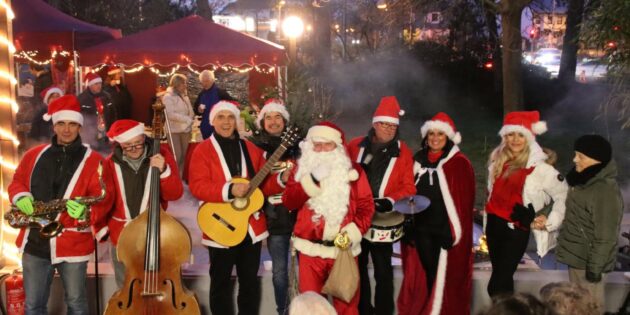 Die MIL-Walking-Band mit Alex Kiesow (von links), Hans Johnsen, Helmut Wehe, Günter Fröhlich und Hans-Jürgen Götz (rechts neben dem Weihnachtsmann) erfreuten ihr Publikum auf dem Vorplatz des Alten- und Pflegeheims Mariä Verkündigung mit schönen Weihnachtliedern, begeistert auch Heimleiterin Rebecca Bauer und ihr Team. Foto: Hannelore Nowacki