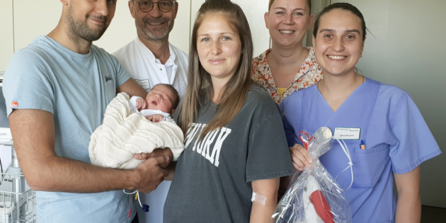 Frauenklinik-Chefarzt Prof. Dr. Thomas Hitschold besuchte die „Jubiläumseltern“ (vorne) gemeinsam mit Kreißsaal-Leiterin Diana Roesner und Henrys-Hebamme Isabell Nazarov (von links). Foto: Klinikum Worms