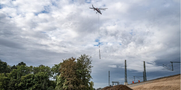 Ein Hubschrauber fliegt ein neues Signal an die Bahnstrecke. Foto: DB AG/Uli Planz