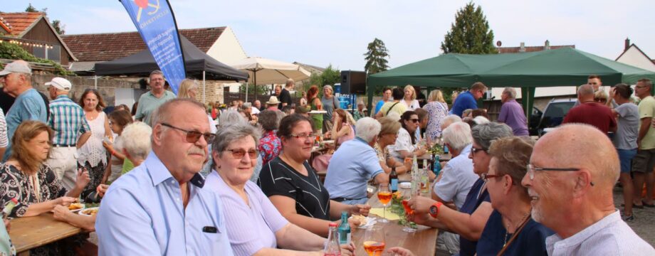 Gefeiert wurde auf dem vorderen Bereich des weitläufigen Schotterplatzes am Rathaus – gemütlich beisammen sein und den schönen Sommerabend im Herzen von Biblis mit Wein, Pommes und fleischlichen Genüssen mit musikalischer Untermalung genießen war das Programm. Foto: Hannelore Nowacki